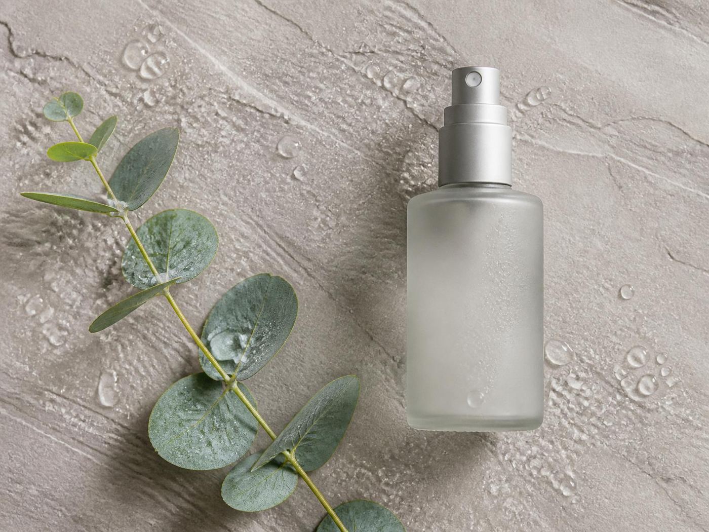 Respi-VIVA bottle flat-lay with eucalyptus on soft stone.